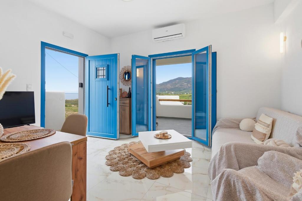 a living room with blue doors and a couch at Cassiopeia in Akrotiri