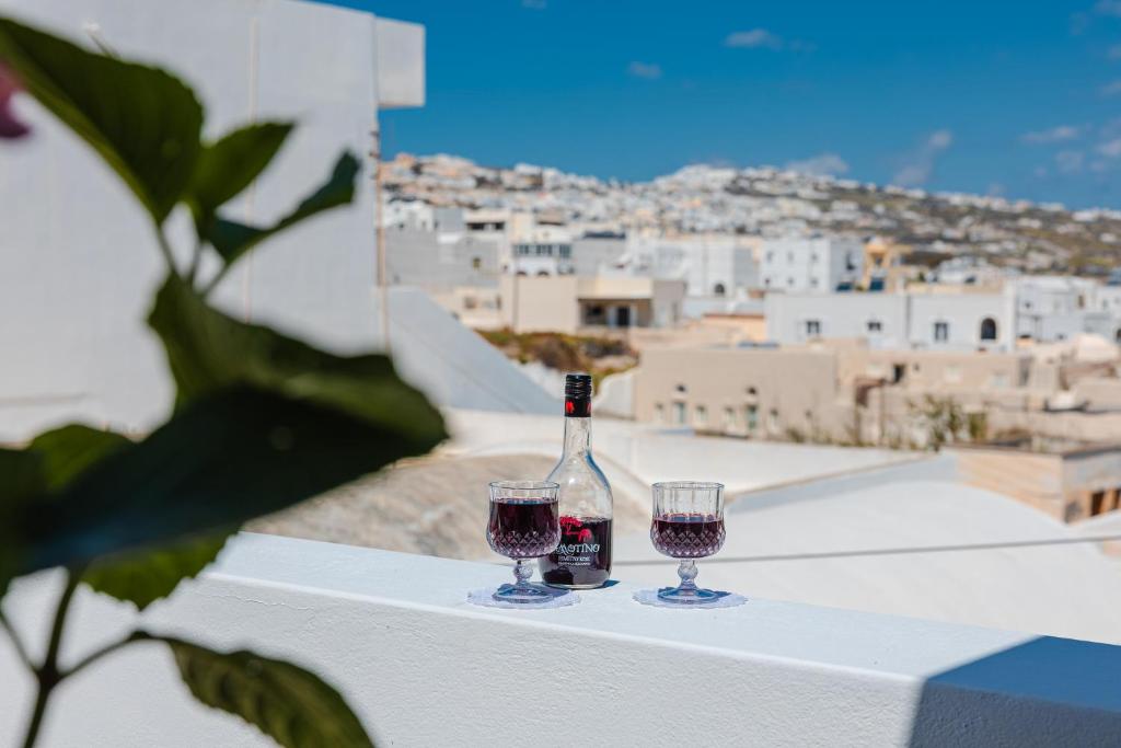 a bottle of wine and two glasses on a table at Begi Luxury Villas in Karterados