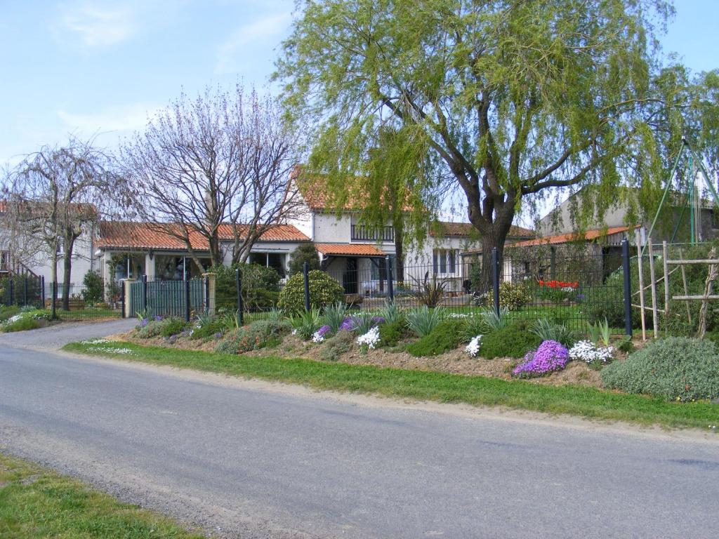 una casa con un giardino di fiori sul lato di una strada di Chambres d'Hôtes Vignes et Loire a Drain