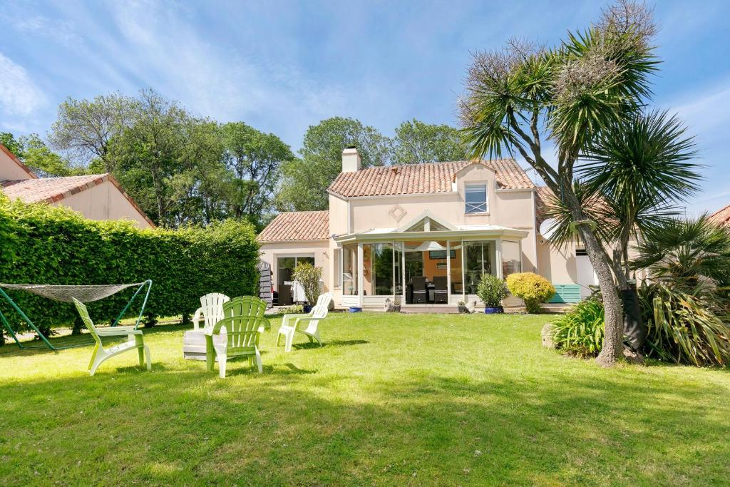 a house with a yard with chairs and a palm tree at Chez Anne-Marie et Constant in Pornichet
