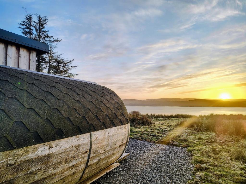 a wooden boat sitting on the shore of a lake at Faodail Studio in Portree