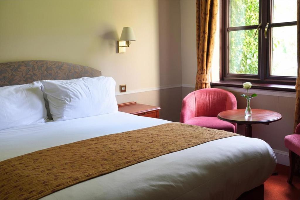 a hotel room with a bed and a window at The Tollgate Hotel in Steyning