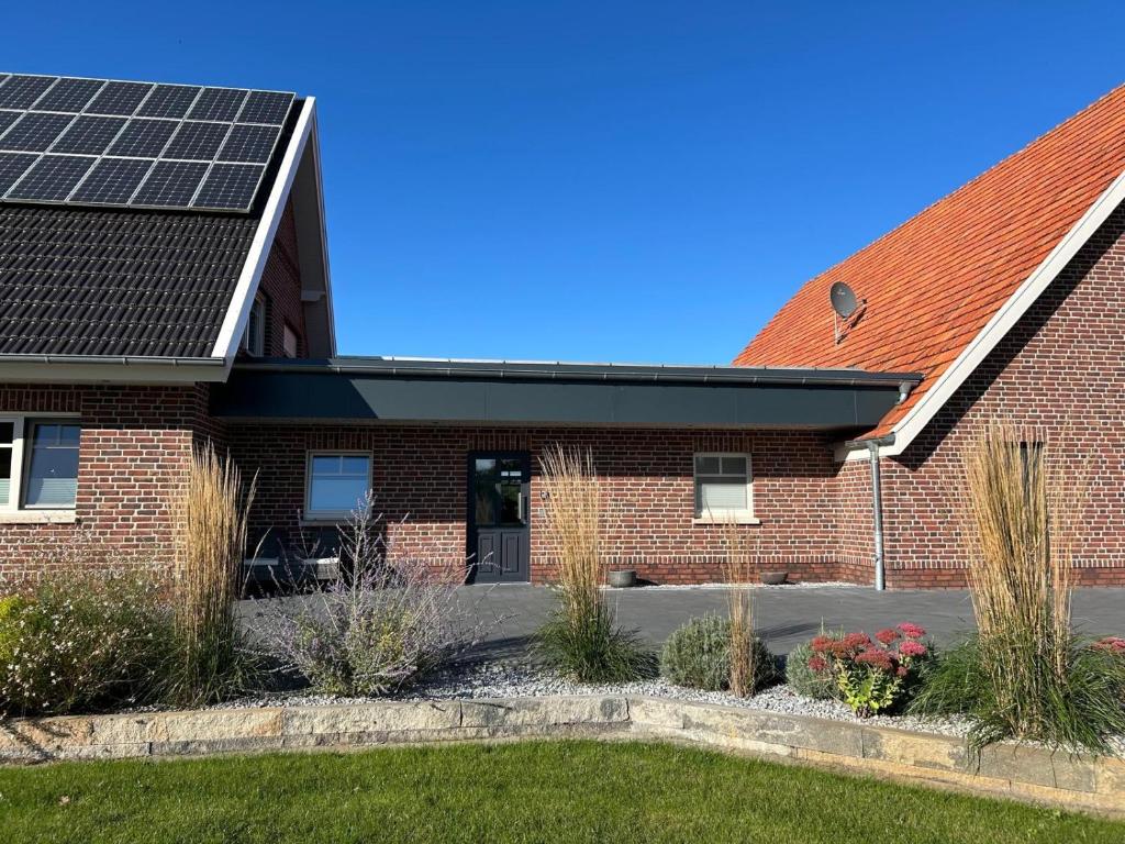 a house with solar panels on the roof at Ferienwohnung am Vechtedamm in Hoogstede