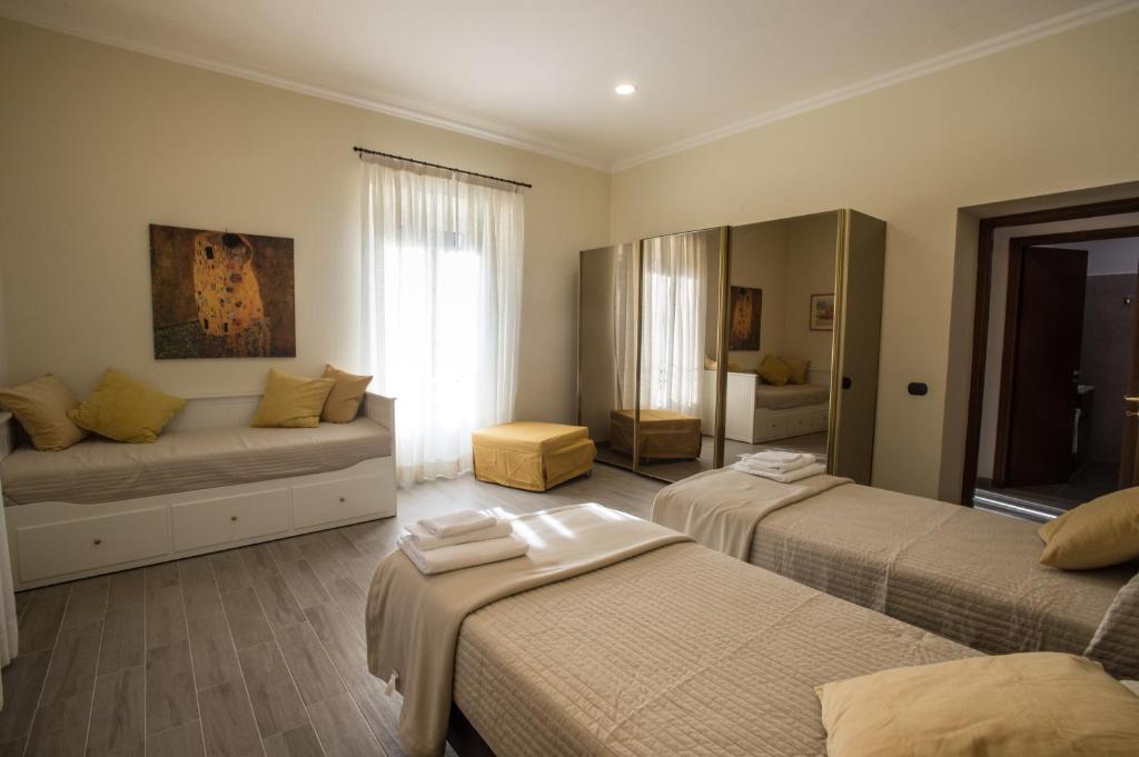 Habitación de hotel con 2 camas y sofá en Le Cupoline, en Roma