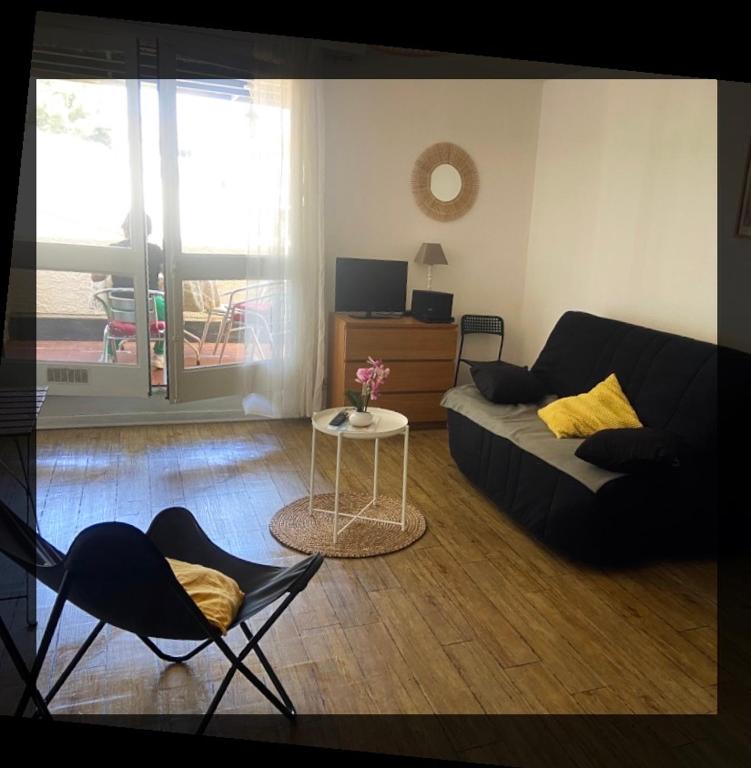 a living room with a couch and a table and chairs at location studio traversant , lit King size,2 terrasses in Sausset-les-Pins