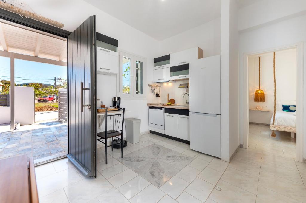 a kitchen with white cabinets and a table in a room at Zen Milos Green Apple in Pollonia