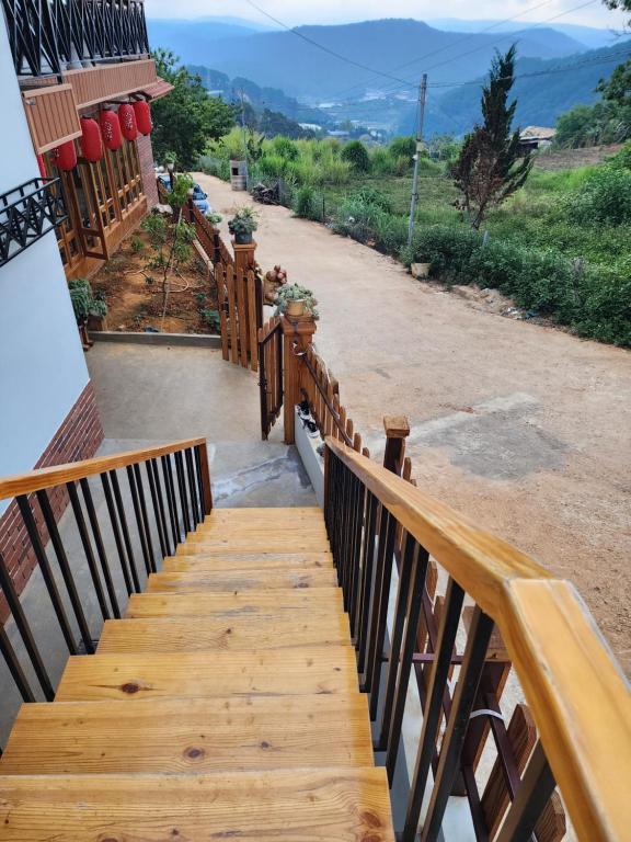 a wooden staircase leading up to a house with mountains in the background at Coffee Myhome in Kon Rung (1)