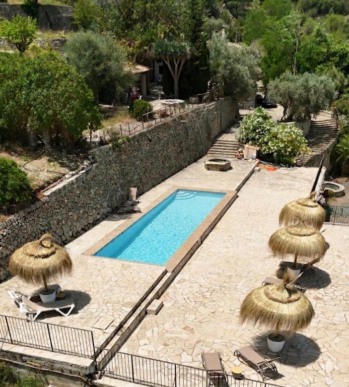 a swimming pool with two straw umbrellas and a swimming pool at Agroturismo Finca Can Sec in Alaró