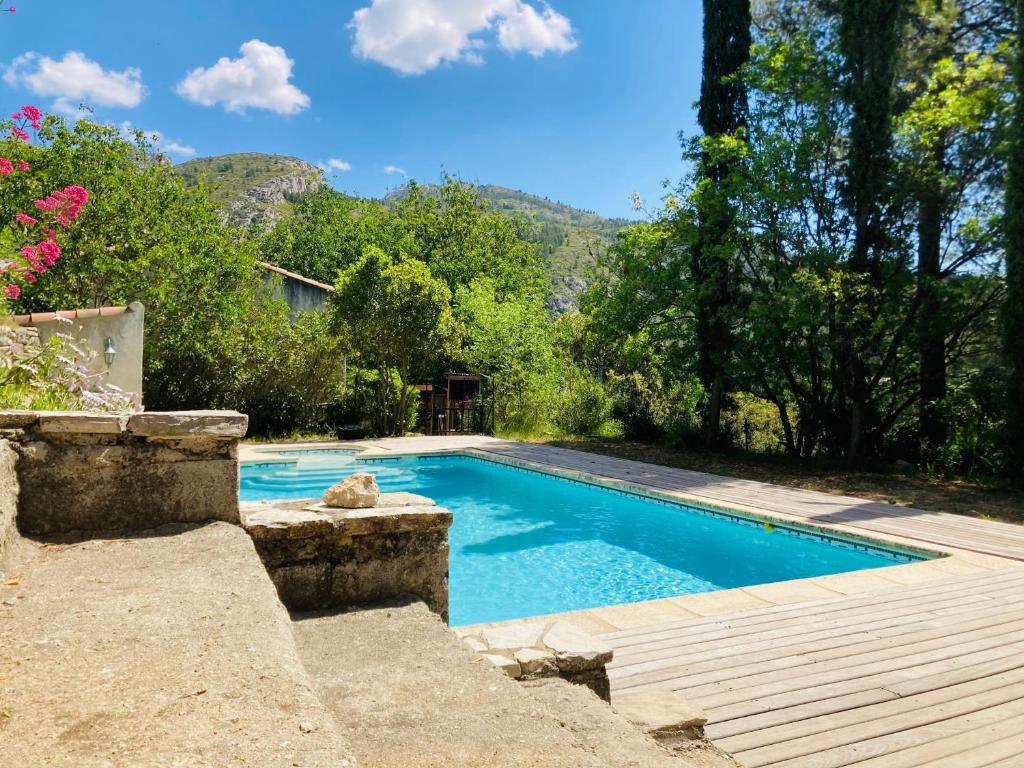 a swimming pool in a yard with a wooden deck at Villa de la Baume in Gémenos