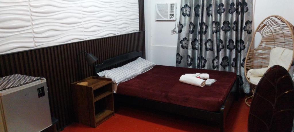 a small room with a small bed with towels on it at YANTO BEACH HAUS at CAGWAIT WHITE BEACH in Cagwait