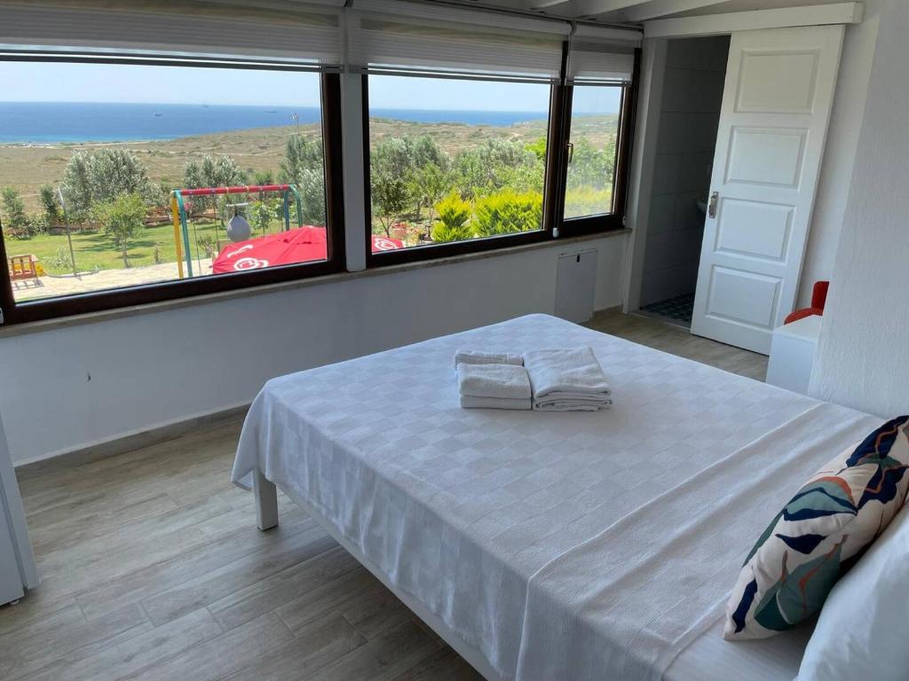 a bedroom with a bed and a view of the ocean at Villa Yalıca in Bozcaada