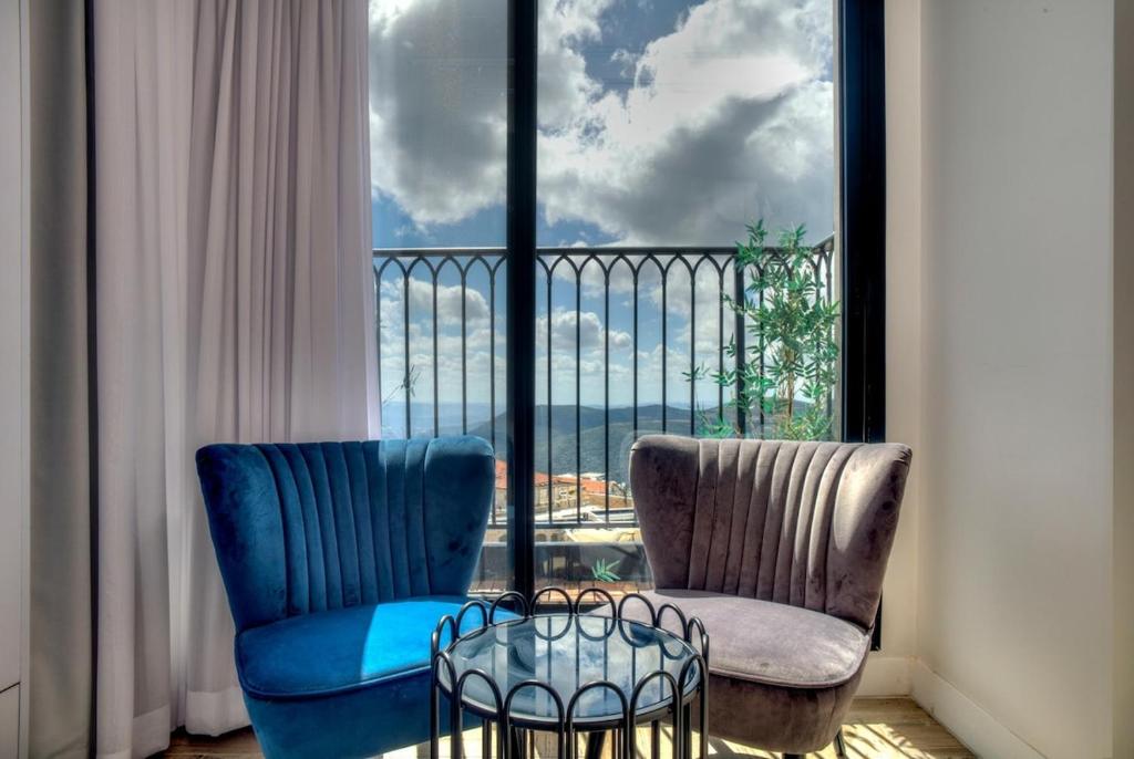 two chairs and a table in front of a window at Open Skys in Safed