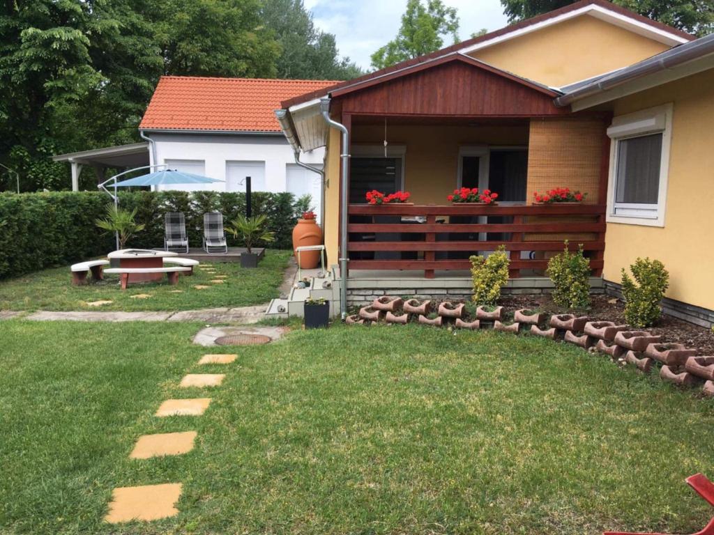 a backyard with a house with a garden with a bench at Lena Lodge in Fonyód