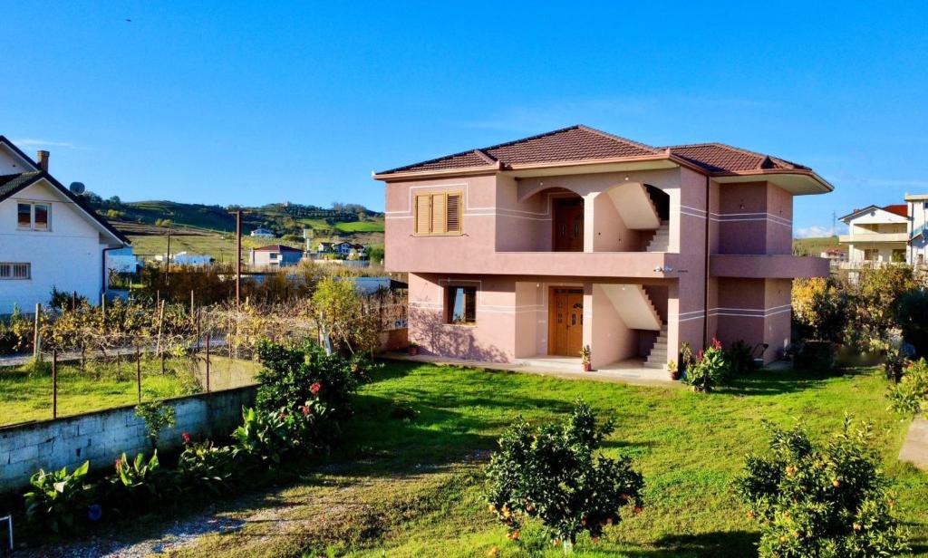 a pink house with a green yard at Dreamy Heaven Escape Villa in Shijak