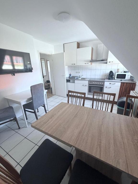 a kitchen and dining room with a wooden table and chairs at AlWi Apartment Wohnung 3 in Moringen