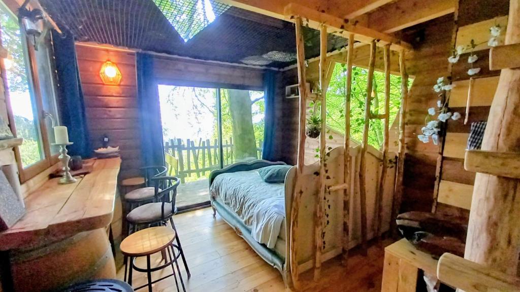 a bedroom with a bed in a wooden cabin at Cabane du Druide Domaine de Fangorn in Glux