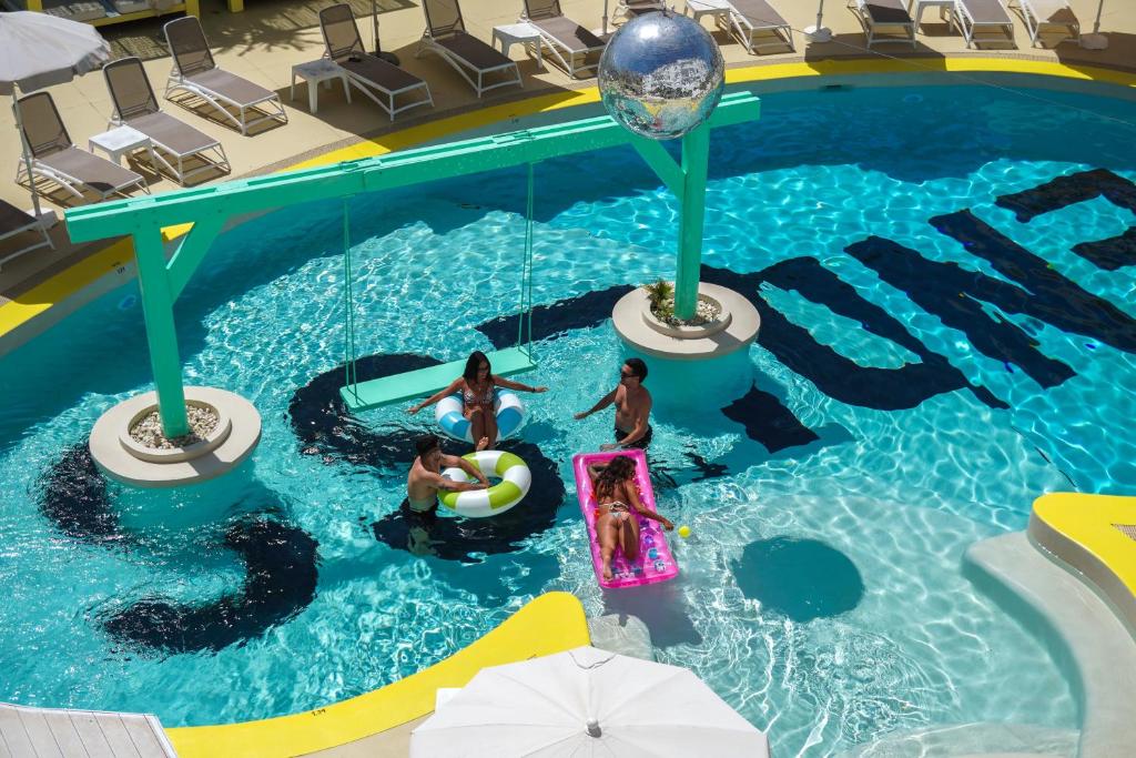 a group of people in a swimming pool at ENDLSS BEACH & DISCO HOTEL IBIZA Adults Only in San Antonio Bay