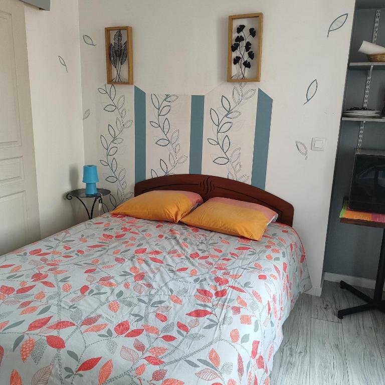 a bedroom with a bed with orange pillows on it at Chambre pour 2 personnes à Formigny RDC in Formigny