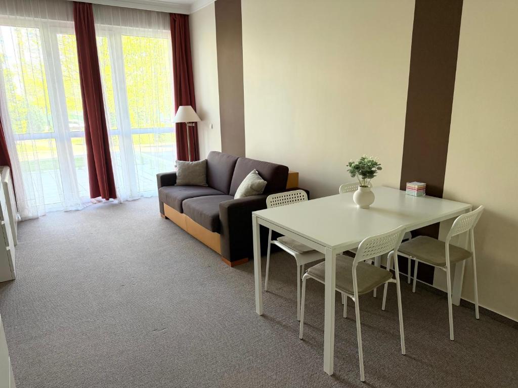 a living room with a table and a couch at Tóth Wellness Apartman in Zalakaros