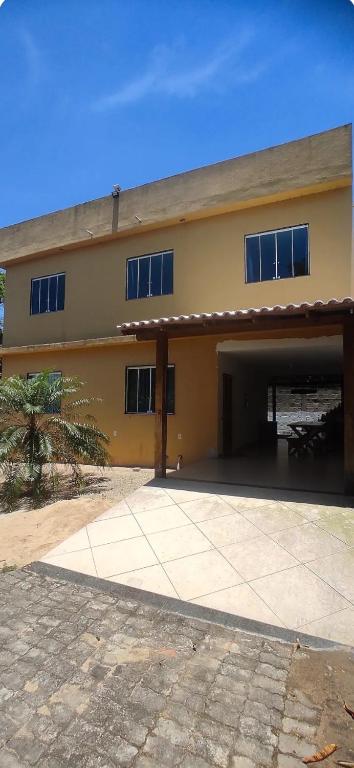 a large yellow building with a garage at Casa de praia castelhanos in Anchieta