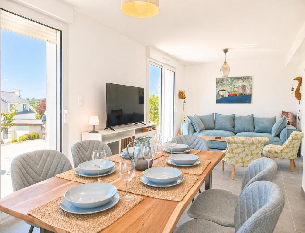 a living room with a table and chairs at La Maison des Écumes in Crozon