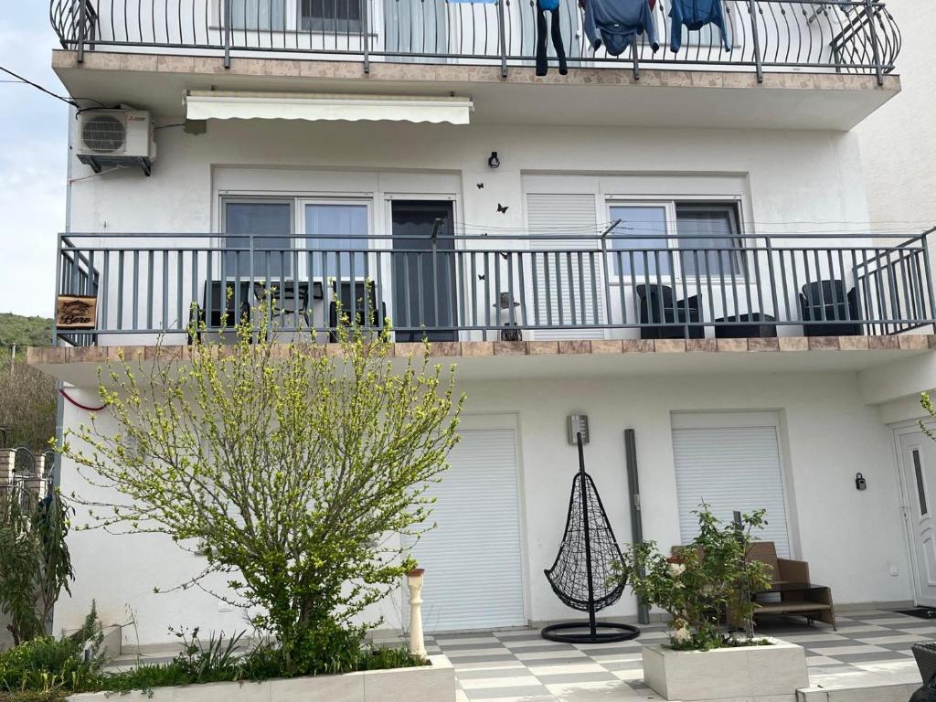 a white building with a balcony with chairs on it at Apartment Boro in Selce