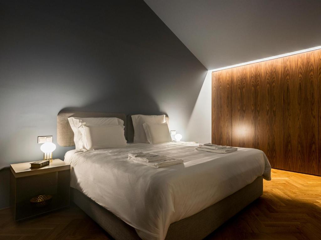 a bedroom with a large bed with a wooden wall at Domum 2 in Porto