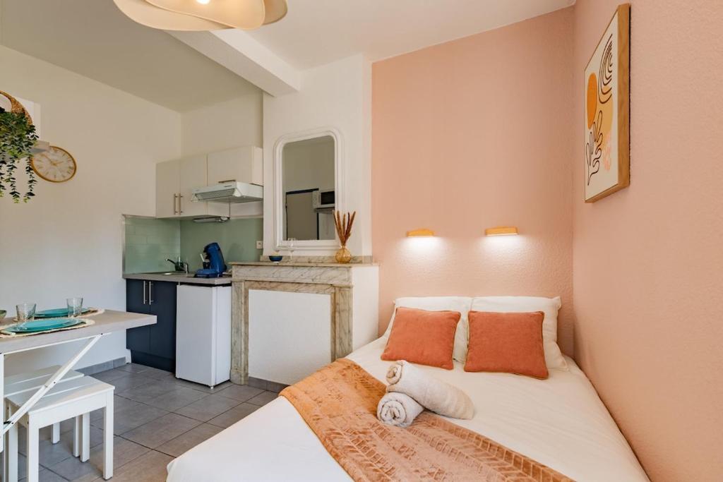 a small bedroom with a bed and a kitchen at Le Colibri in Foix