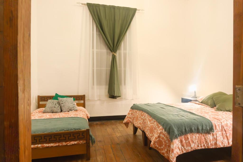 a bedroom with two beds and a window at Gatalegre Hostel in Valparaíso