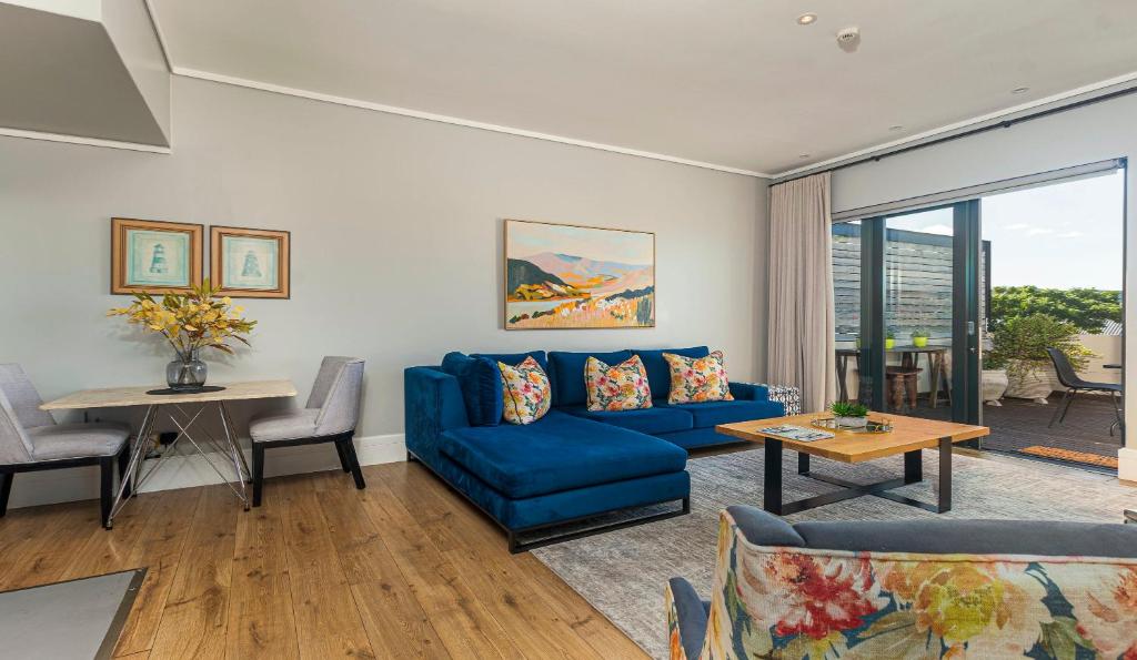 a living room with a blue couch and a table at The Gallery 204 Luxury Apartment in Knysna