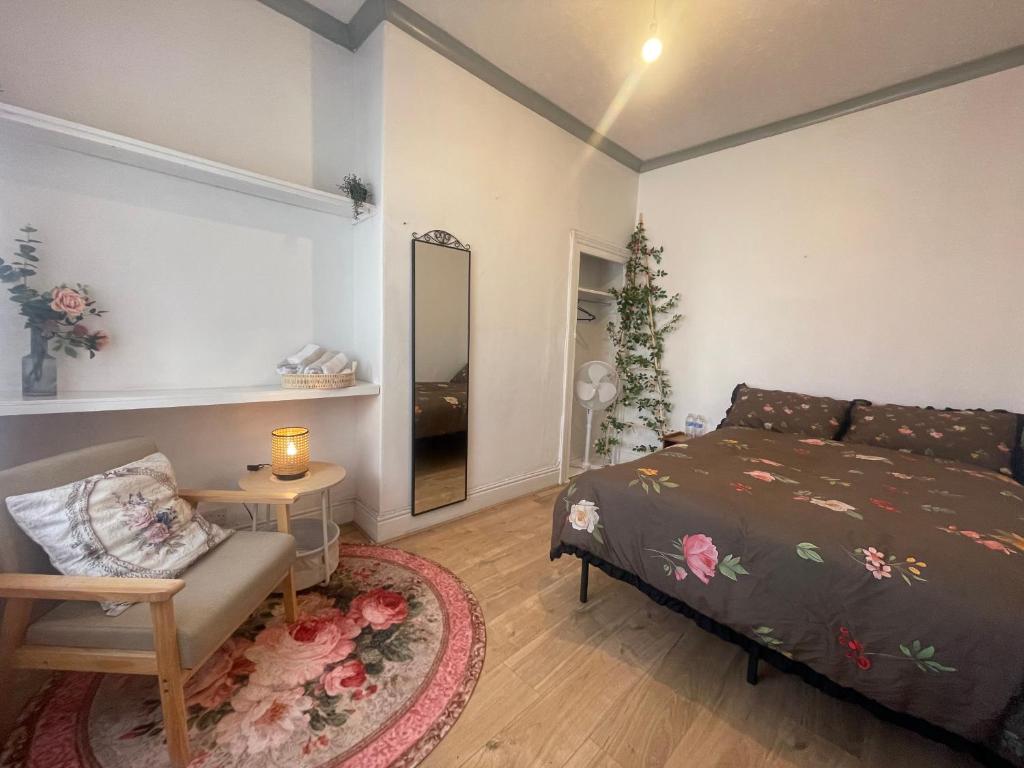 a bedroom with a bed and a chair and a mirror at Rose Cozy House in Stockton-on-Tees