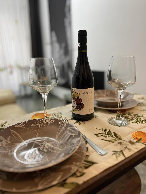Eine Flasche Wein und zwei Gläser auf einem Tisch in der Unterkunft mistral'25 in Cefalú