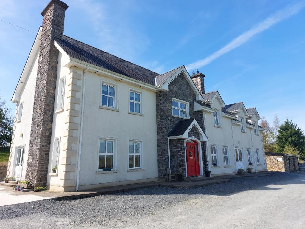 a large white house with a red door at Molly's Self Catering Accommodation in Cavan