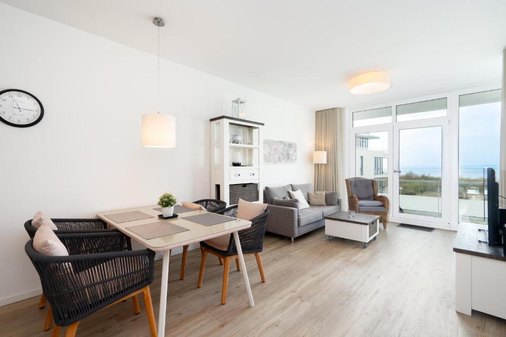 a living room with a table and a living room with a couch at Südkap B-07 in Pelzerhaken