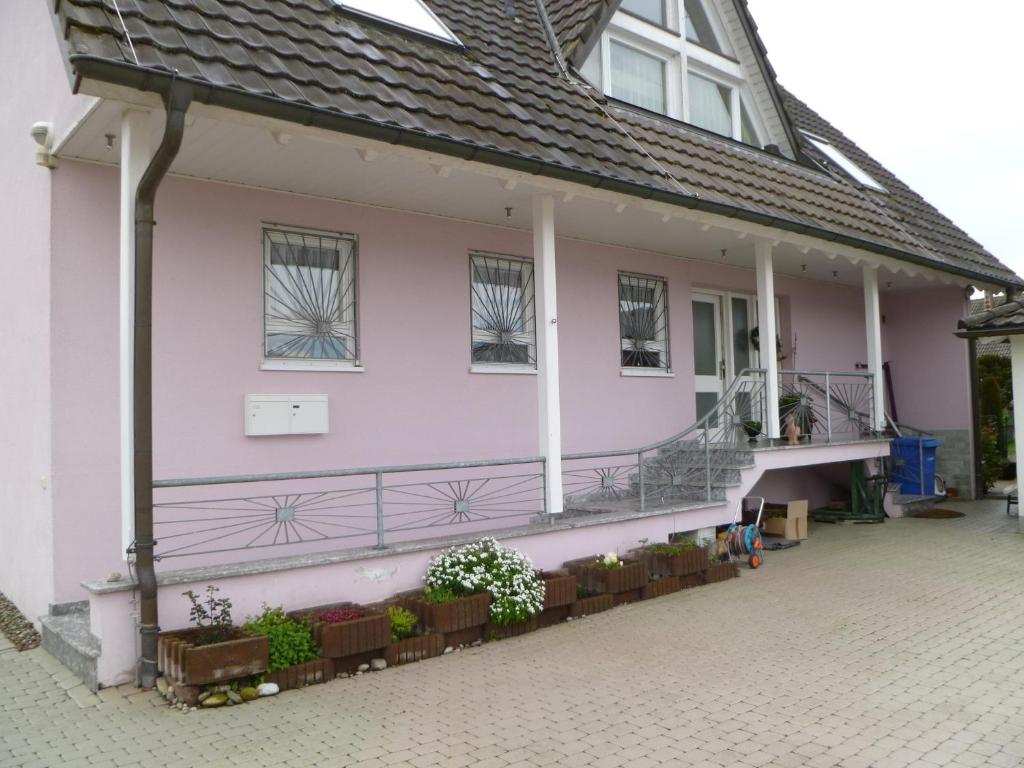 a pink house with a balcony and windows at Villa XADAYU, Appartment in Reichenau