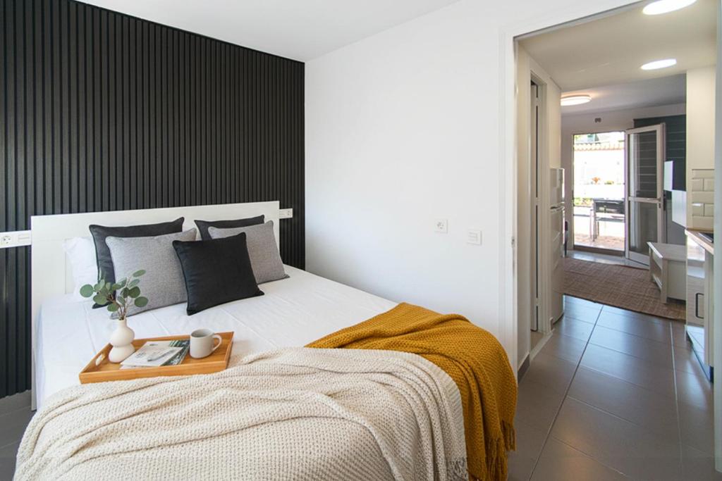 a bedroom with a large bed with a wooden tray on it at WELCS APARTAMENTO 342 PDA con terraza in Platja d'Aro