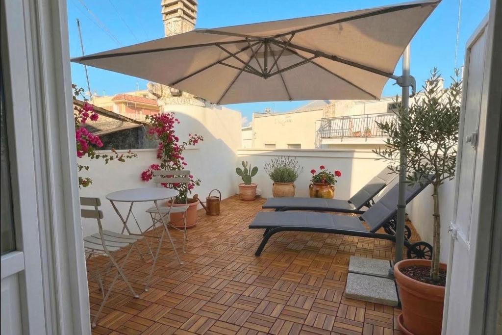 a patio with an umbrella and a table and chairs at Dimora Camponobile - Turi in Turi