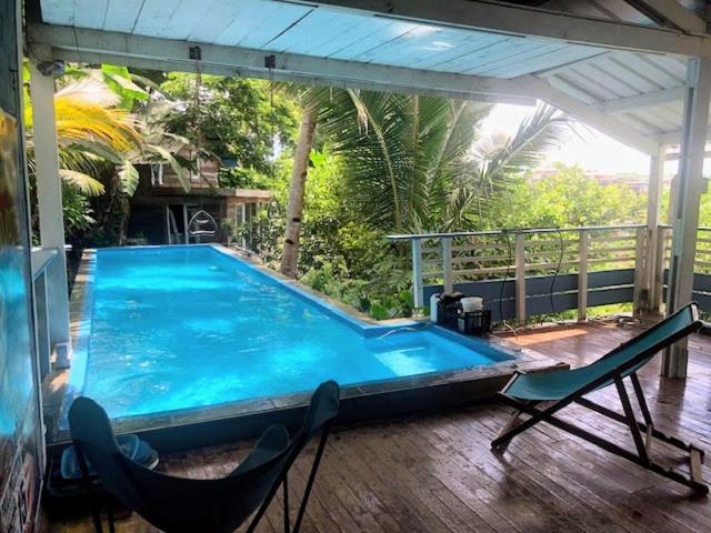 a large swimming pool on a deck with two chairs at La villa bleue in Koungou