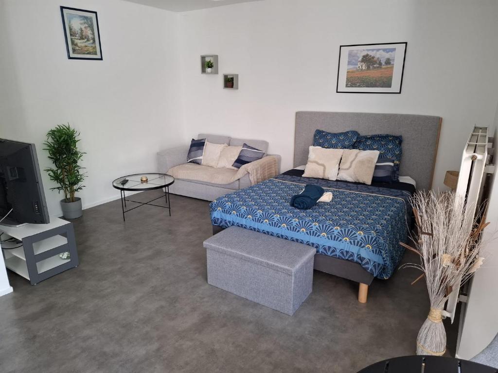 a living room with a bed and a couch at Studio moderne 33m2 Design cosy Wi Fi gratuit in Courcouronnes
