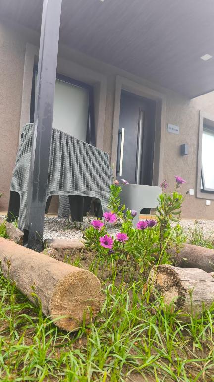 a house with a tv and flowers in a yard at Cabañas PxA in Villa Anizacate