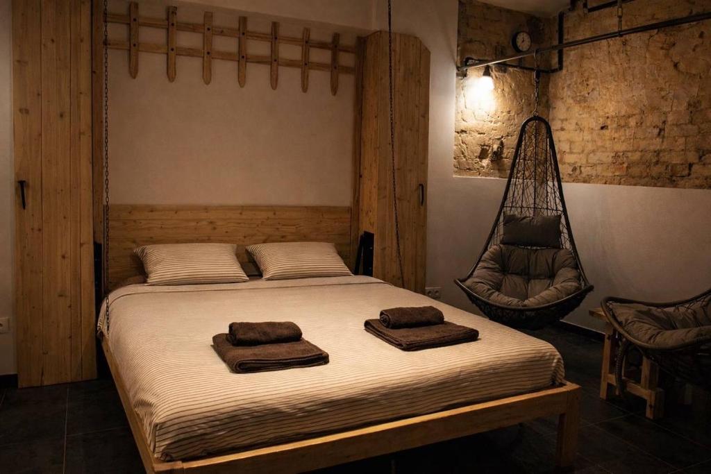 a bedroom with a bed with two towels and a hammock at Jacuzzi Loft in the Center of Riga in Riga