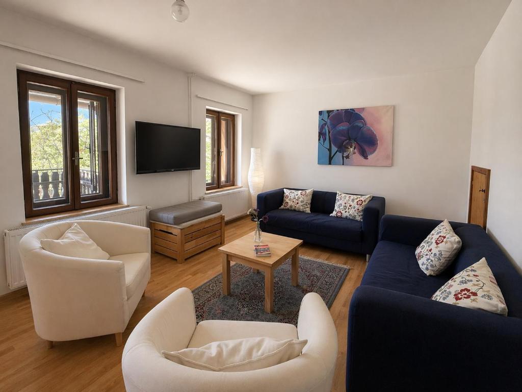 a living room with two couches and a tv at Rose Cottage in Bovec
