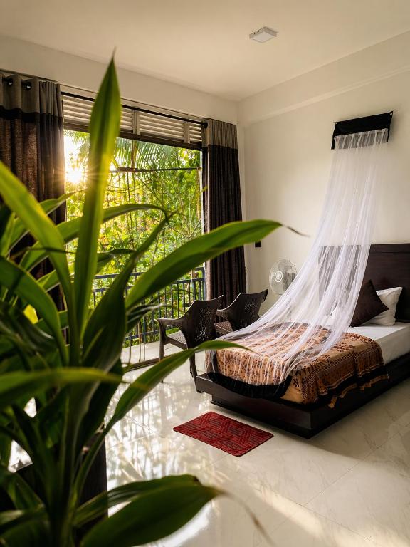 a bedroom with a bed with a mosquito net at Ella Odyssey Inn in Ella