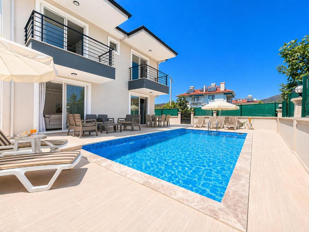 a villa with a swimming pool and patio furniture at Villa Maya in Ortaca