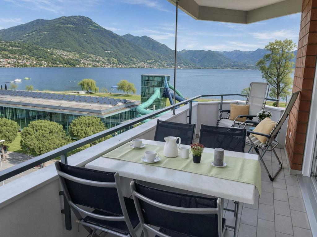 a table and chairs on a balcony with a view of the water at Al Lido by Fewotessin in Locarno