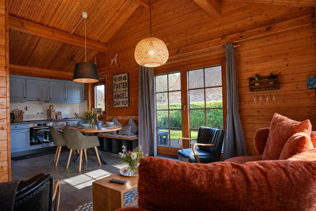 a living room and kitchen in a log cabin at Küstenhaus Silbermöwe in Cuxhaven