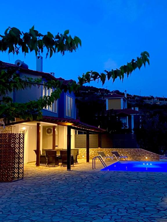 a house with a swimming pool at night at Apollo Romantic Sea View Villa in Kiveri