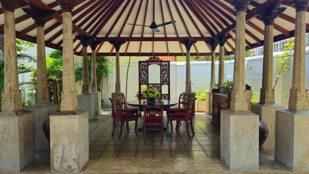 a wooden gazebo with a table and chairs at Nora Lyn - Colombo in Colombo