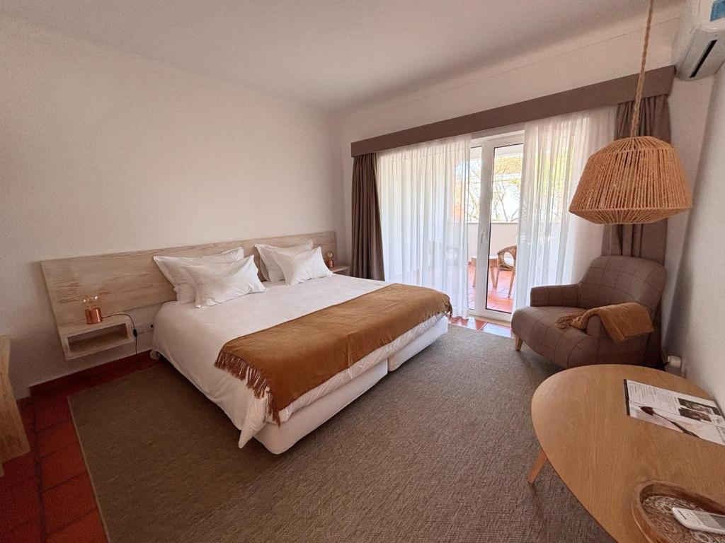 a bedroom with a large bed and a window at Pátio das Ribeiras in Almeirim