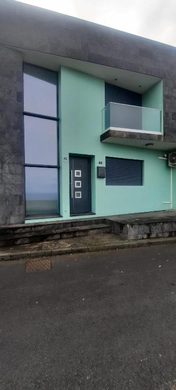 a blue building with two windows on a street at KasaNova in Rabo de Peixe